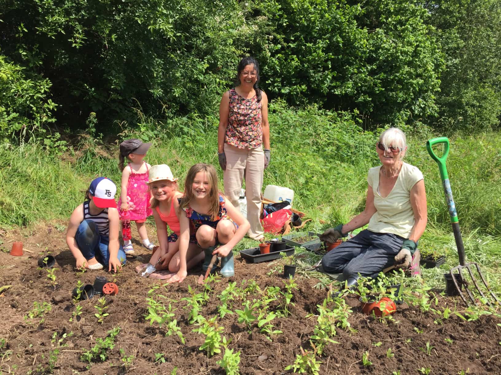 Children help planting wildflowers, Longacre community orchard, 2019