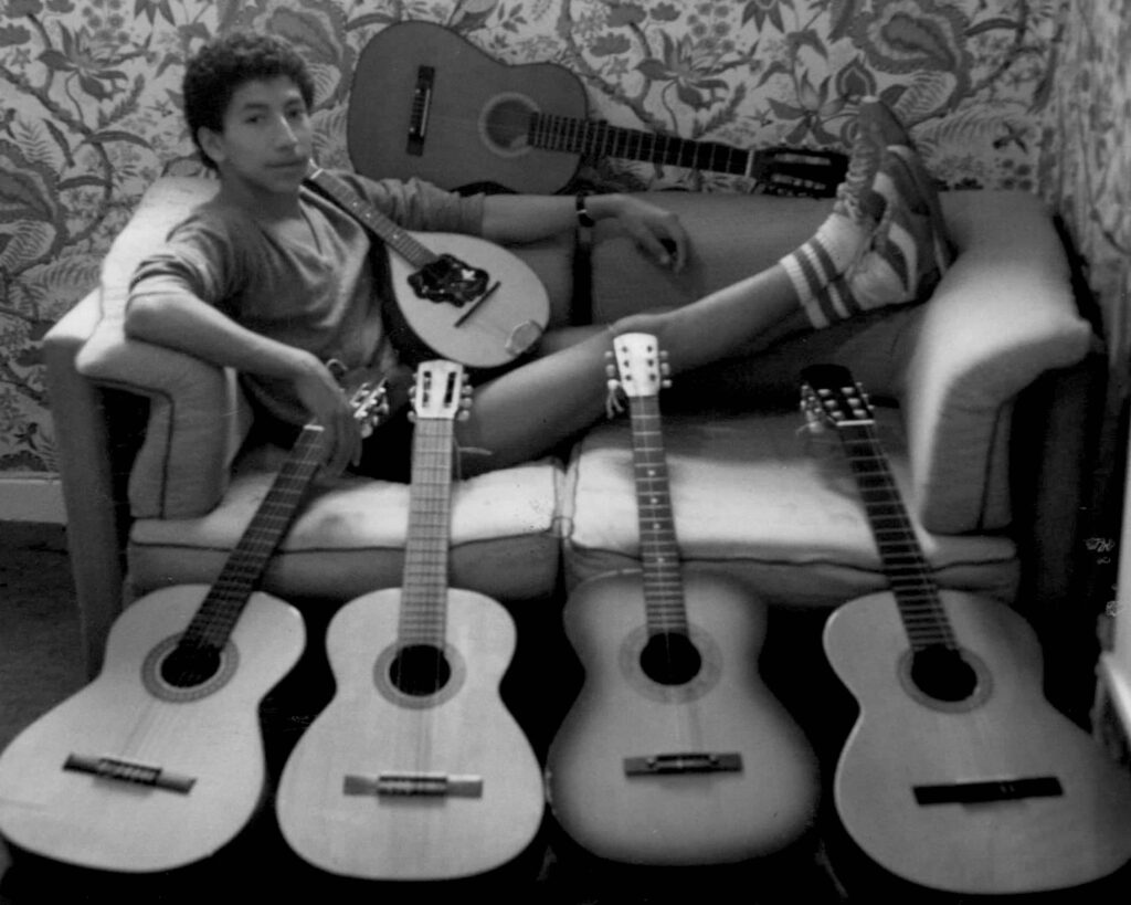 Henry with his many guitars in London, circa 1984, having escaped military conscription in El Salvador. Courtesy of Alicia Mc Keown, daughter of Henry Bran.