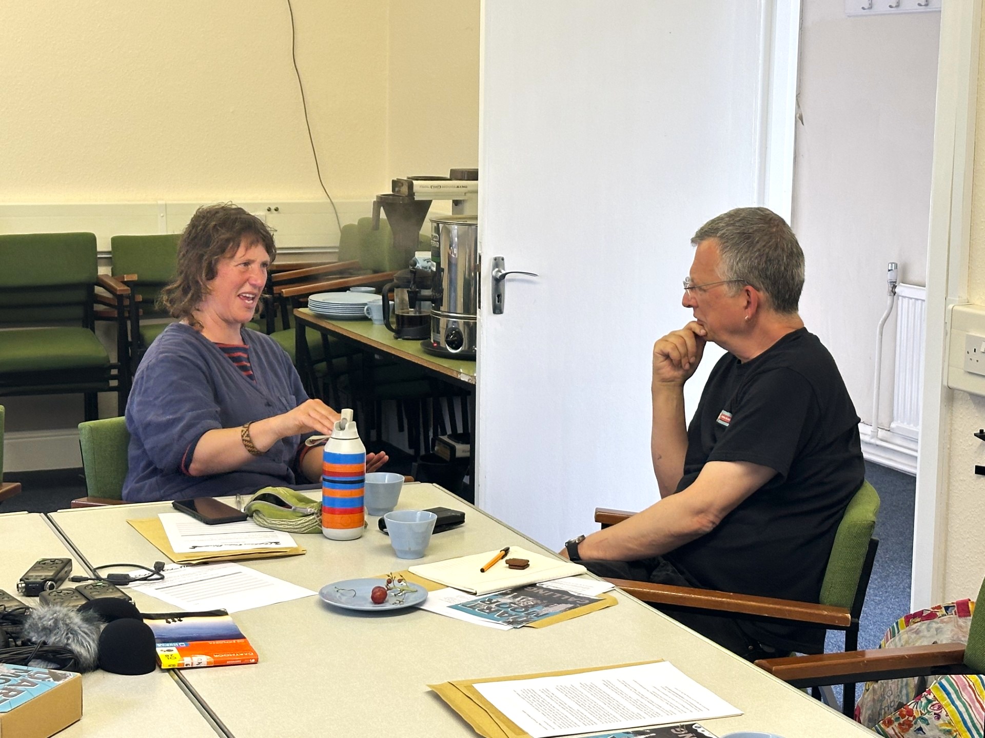 Two people sit talking at a table